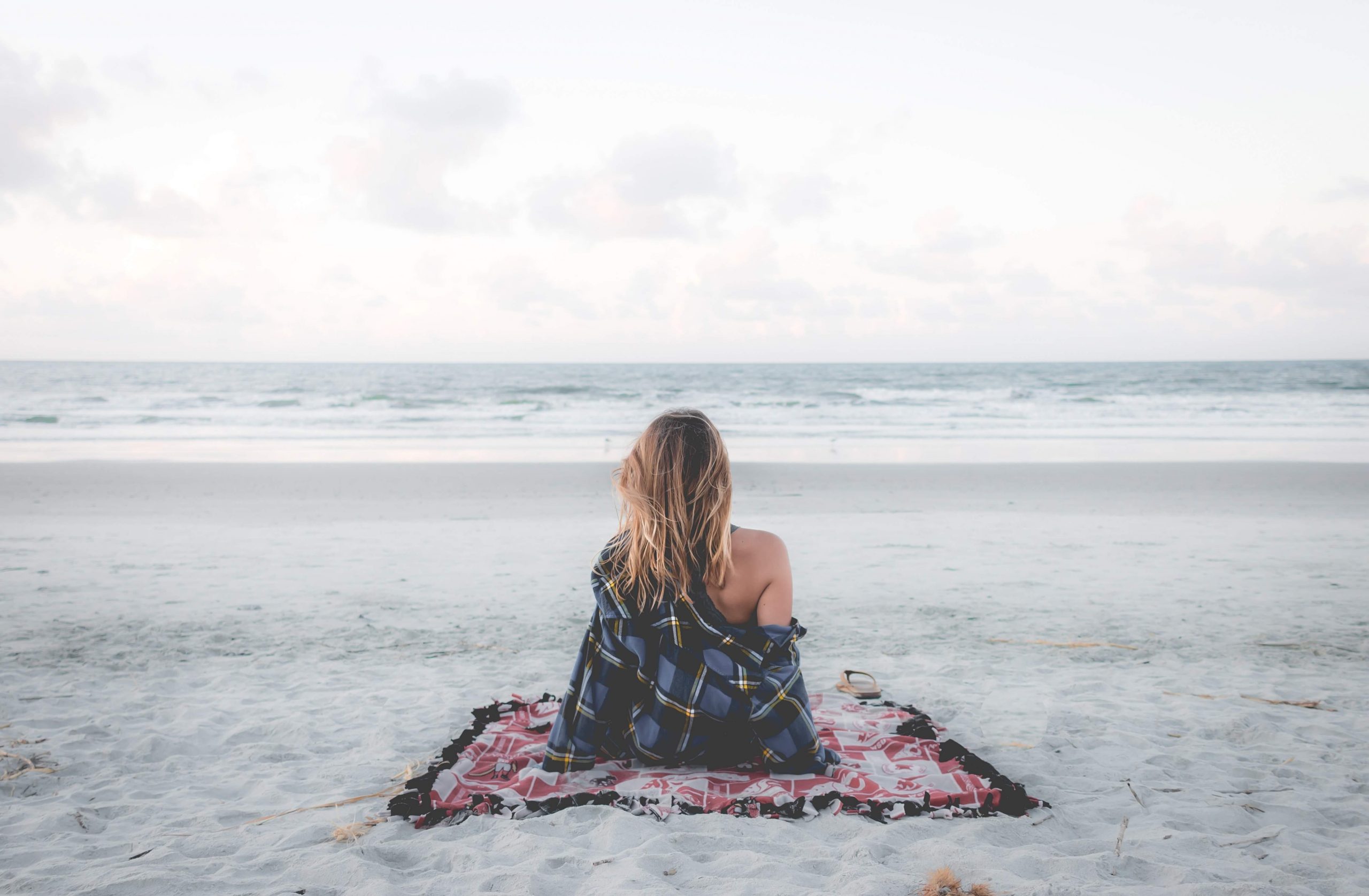woman in a beach looking at waves