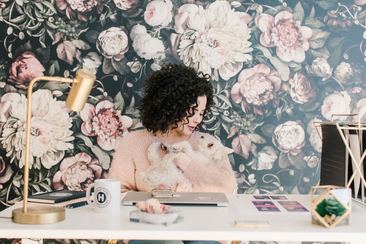 woman holding a dog at a desk