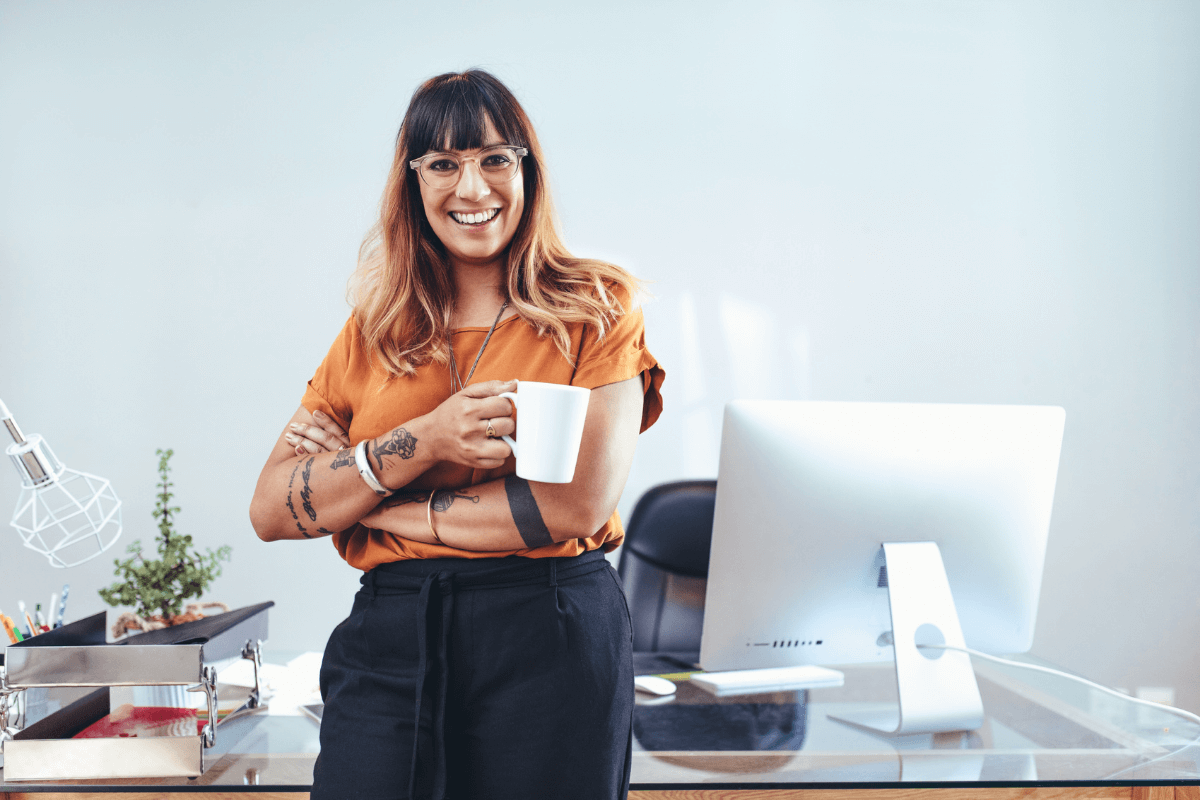 woman with cup of coffee in front of a computer