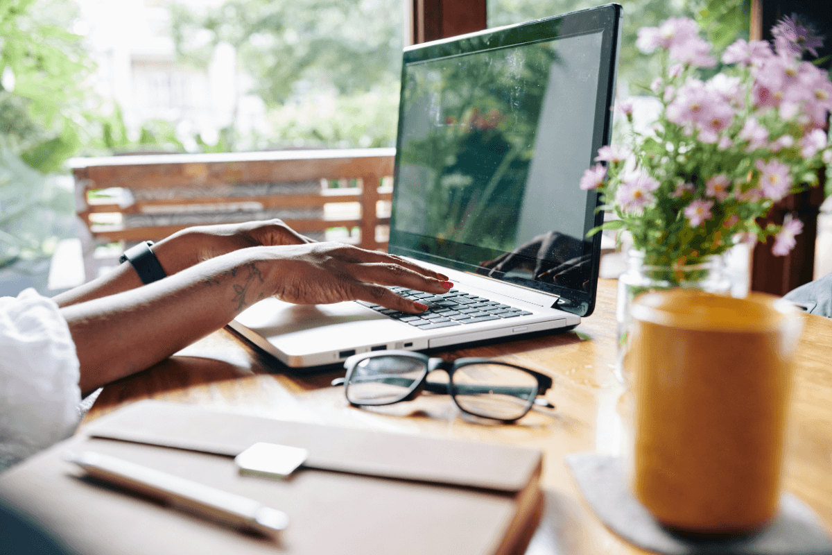 womans hands resting on a laptop
