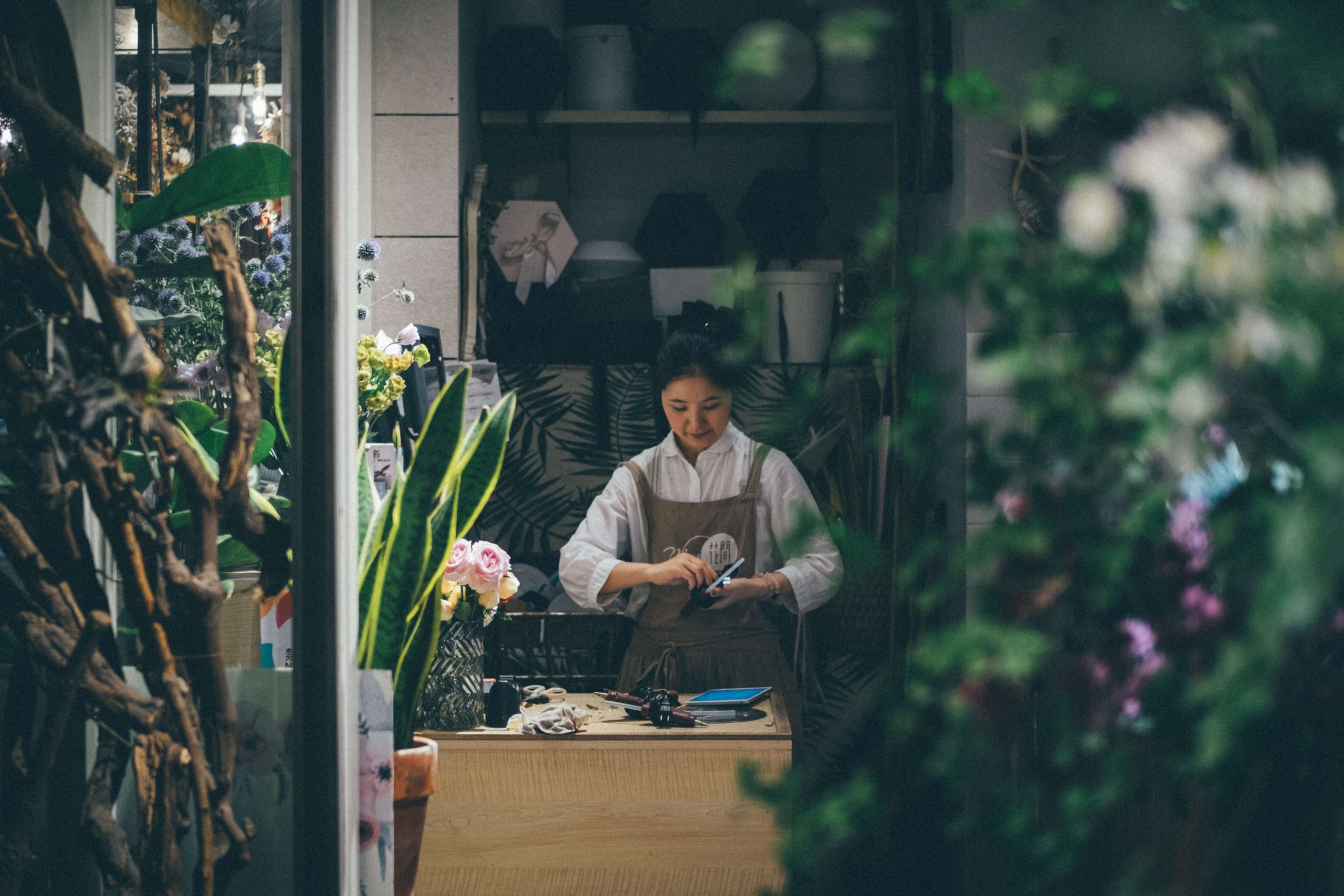 woman in florist shop arranging flowers